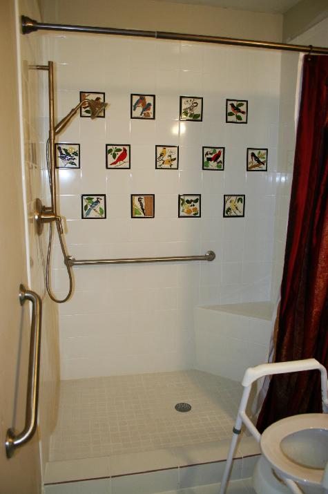 SONG BIRD TILES BY BESHEER ART TILE INSTALLED IN A BATHROOM SHOWER WALL. WHITE FIELD TILES ARE MADE BY DALTILE.
